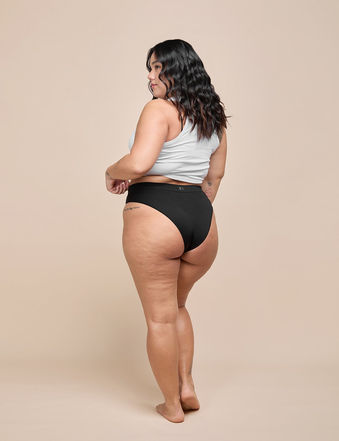 Light bikini with light gray racerback top and black high-waist bottom, side view