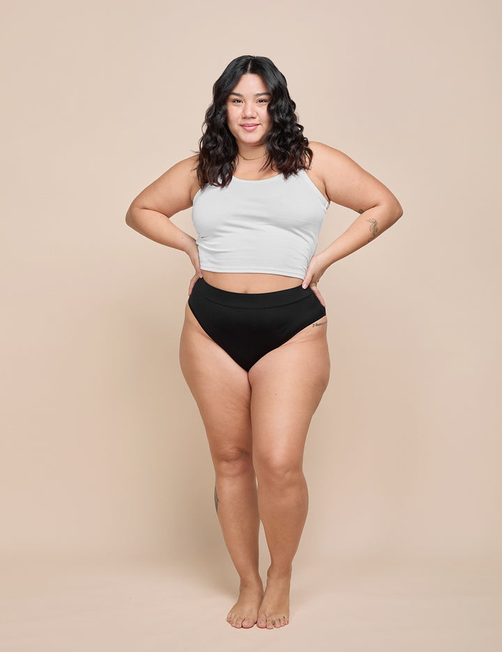 Model wearing the black heavy absorbency bikini with a white tank top
