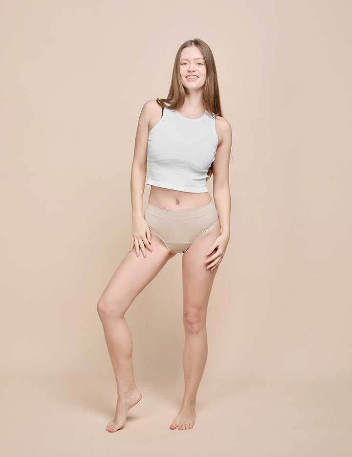 Model wearing the beige moderate absorbency bikini with a white ribbed top