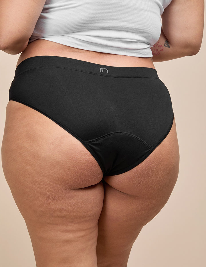 Black moderate absorbency bikini on model, close-up of hip and leg opening