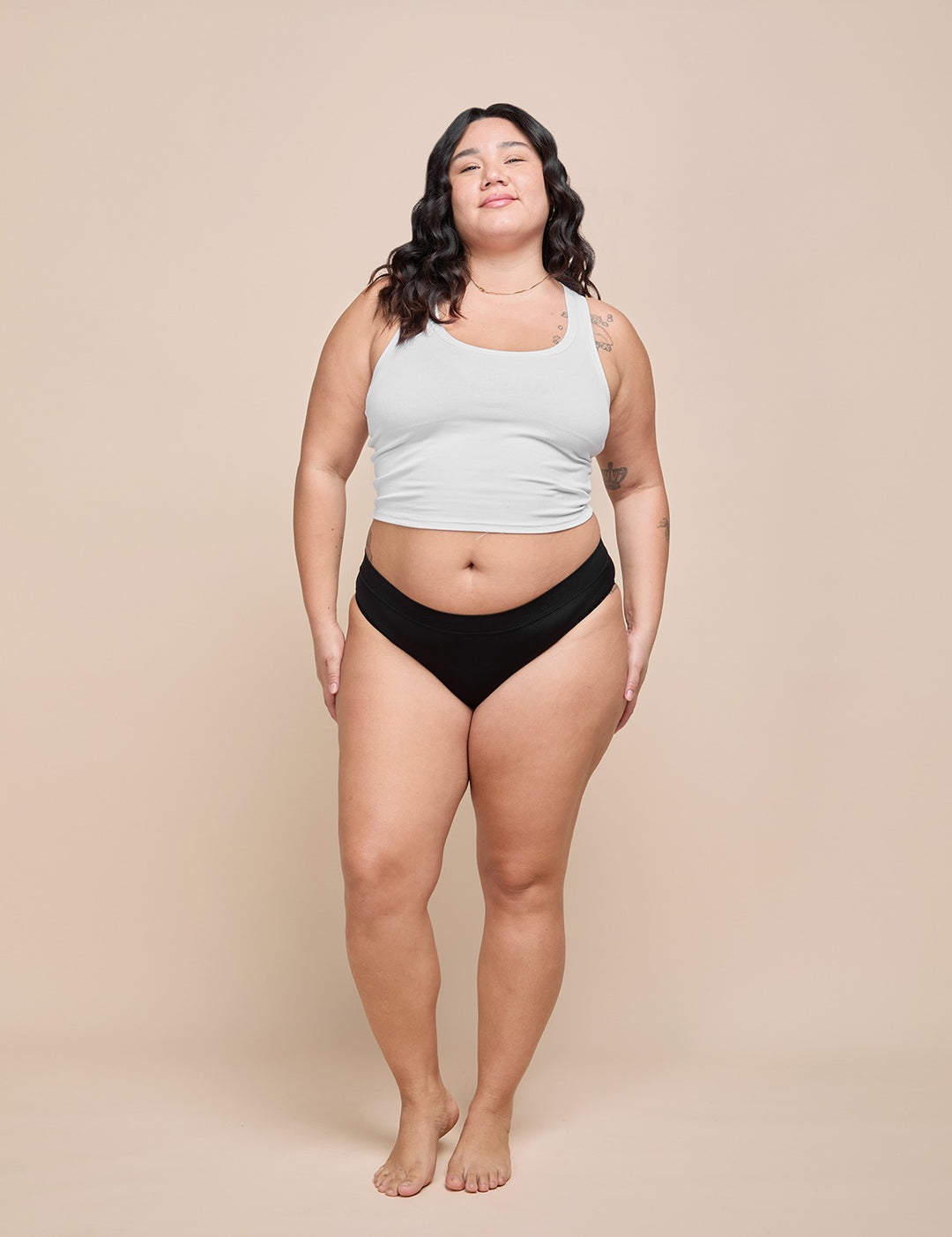 Model wearing the black moderate absorbency bikini with a white ribbed crop top
